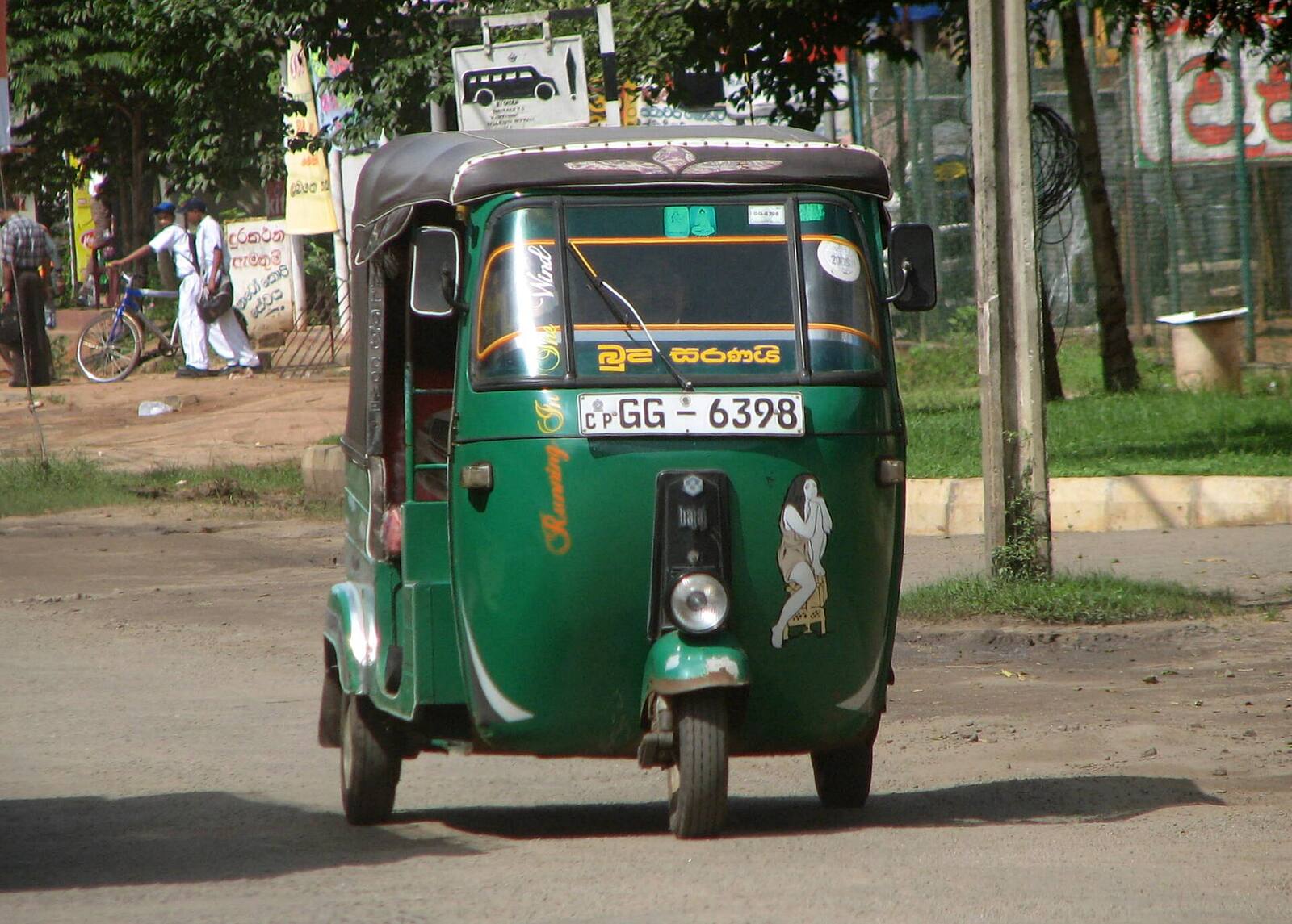 A green tuk-tuk on a road in Sri Lanka